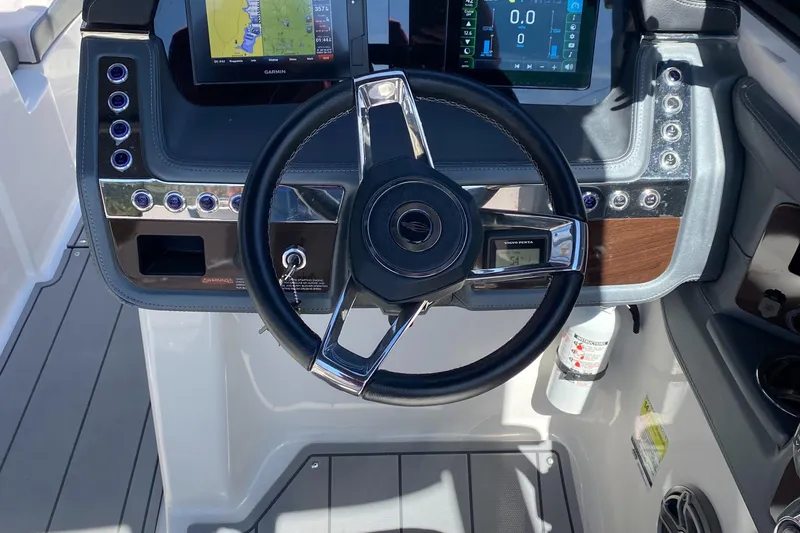 Slide: The Image of 2020 Chaparral 25 SURF boat dashboard with steering wheel and digital displays. - 12