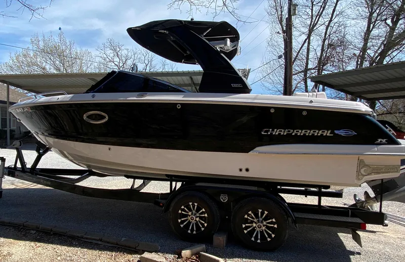 Slide: The Image of 2020 Chaparral 25 SURF boat on trailer, black and white design, parked outdoors. - 3
