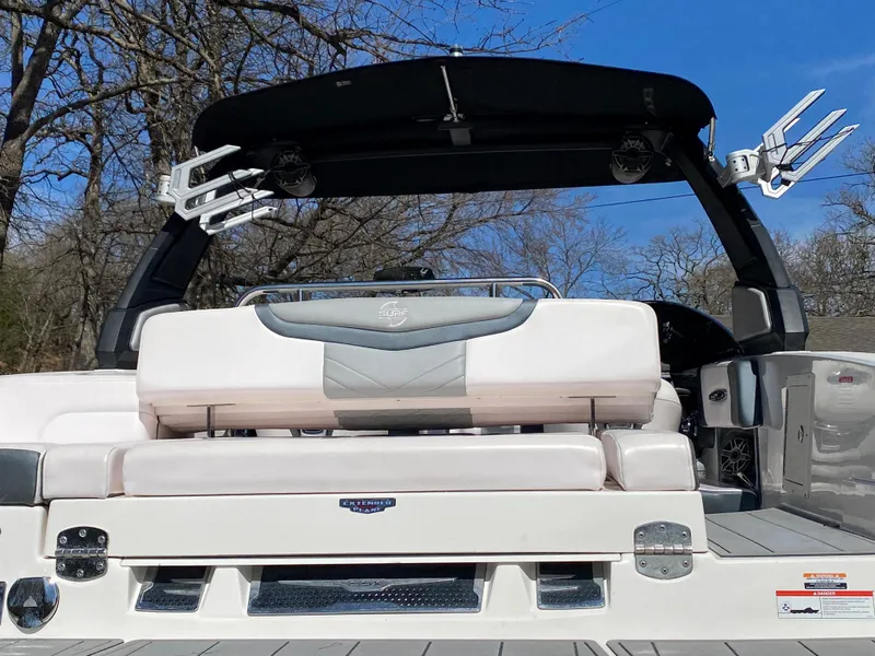 Slide: The Image of 2020 Chaparral 25 SURF boat with sleek seating and modern design, set against a clear sky. - 5