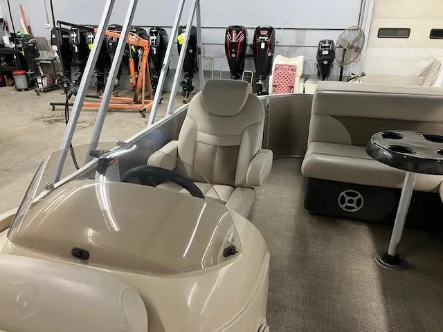 Slide: The Image of 2017 Godfrey Sweetwater 2286 C pontoon boat interior with beige seating and steering console. - 10