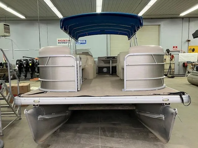 Slide: The Image of 2017 Godfrey Sweetwater 2286 C pontoon boat with blue canopy in a showroom. - 2
