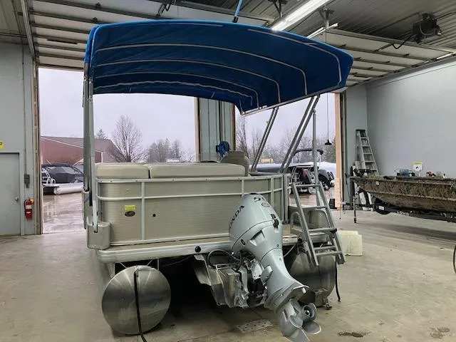 Slide: The Image of 2017 Godfrey Sweetwater 2286 C pontoon boat with blue canopy in a garage. - 3