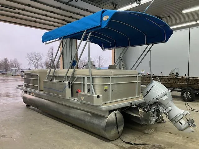 Slide: The Image of 2017 Godfrey Sweetwater 2286 C pontoon boat with blue canopy in a garage. - 4