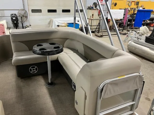 Slide: The Image of 2017 Godfrey Sweetwater 2286 C pontoon boat interior with beige seating and cupholder table. - 9