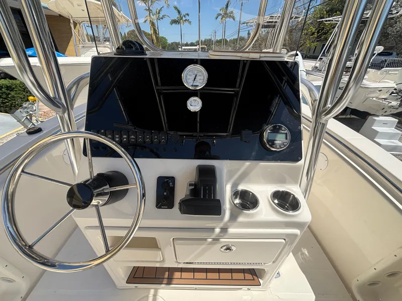 Slide: The Image of 2025 Bulls Bay 200 Center Console boat dashboard with steering wheel and gauges. - 13