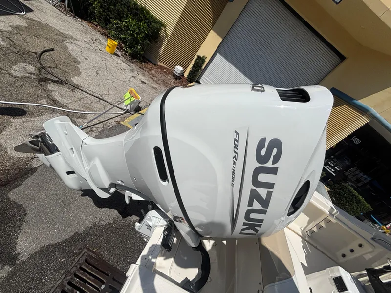 Slide: The Image of 2025 Bulls Bay 200 Center Console with Suzuki outboard motor in a sunny outdoor setting. - 18
