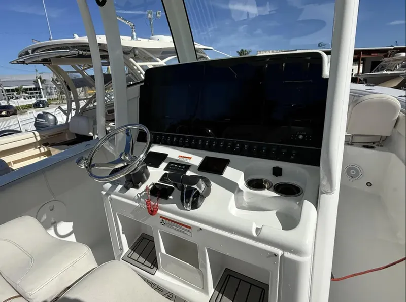 Slide: The Image of 2021 Sea Hunt Gamefish 30 boat console with steering wheel and controls. - 28