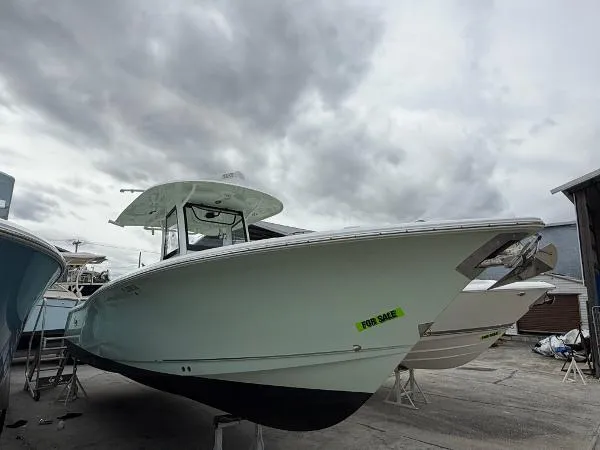 Slide: The Image of 2021 Sea Hunt Gamefish 30 boat for sale, docked under cloudy skies. - 34