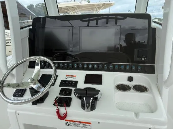 Slide: The Image of 2021 Sea Hunt Gamefish 30 dashboard with steering wheel, dual screens, and controls. - 42