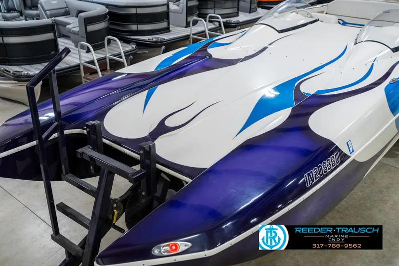 Slide: The Image of 2001 Eliminator 26 Daytona boat with blue and white design, displayed indoors. - 12
