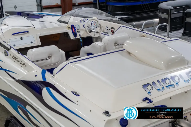Slide: The Image of 2001 Eliminator 26 Daytona speedboat with custom graphics and white interior, displayed indoors. - 15