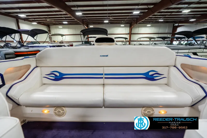 Slide: The Image of 2001 Eliminator 26 Daytona boat interior with white seating and blue flame design. - 20