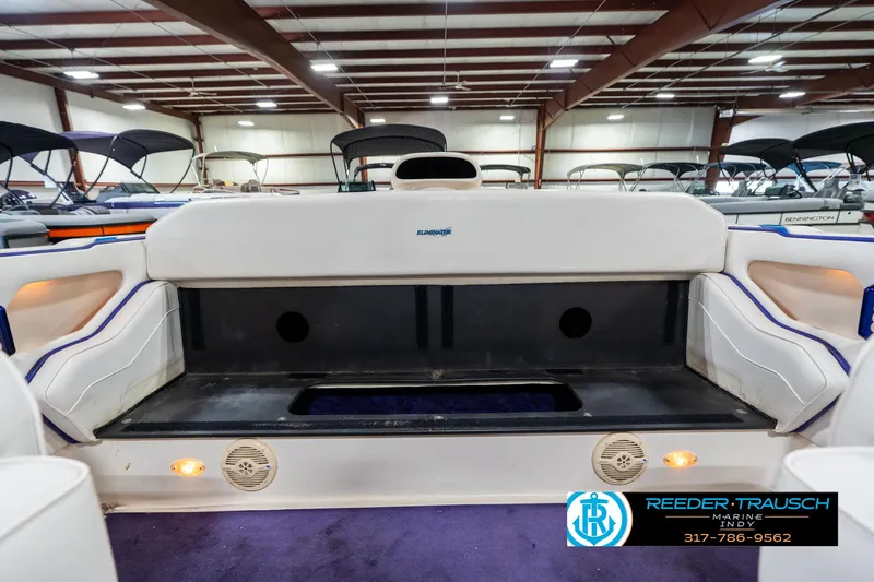 Slide: The Image of 2001 Eliminator 26 Daytona boat interior with seating and storage, showcased in a showroom. - 21