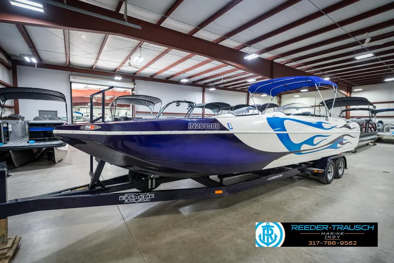 Slide: The Image of 2001 Eliminator 26 Daytona boat with blue flame design in showroom. - 3