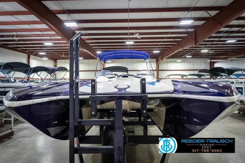 Slide: The Image of 2001 Eliminator 26 Daytona boat in showroom, front view, blue and white design. - 5