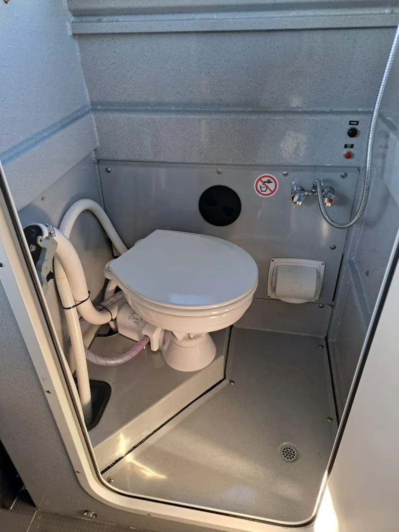 Slide: The Image of 2025 Duckworth 28 Offshore boat bathroom with compact toilet and shower setup. - 5