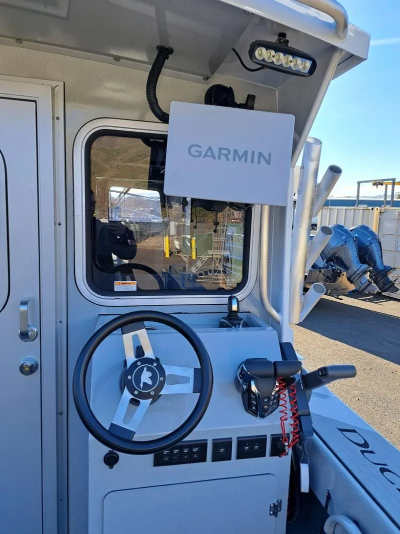 Slide: The Image of 2025 Duckworth 28 Offshore boat cockpit with Garmin navigation system and steering wheel. - 7