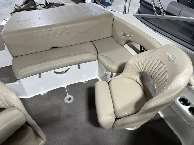 Slide: The Image of 2015 Stingray 215 LR boat interior with beige leather seating and carpeted floor. - 11