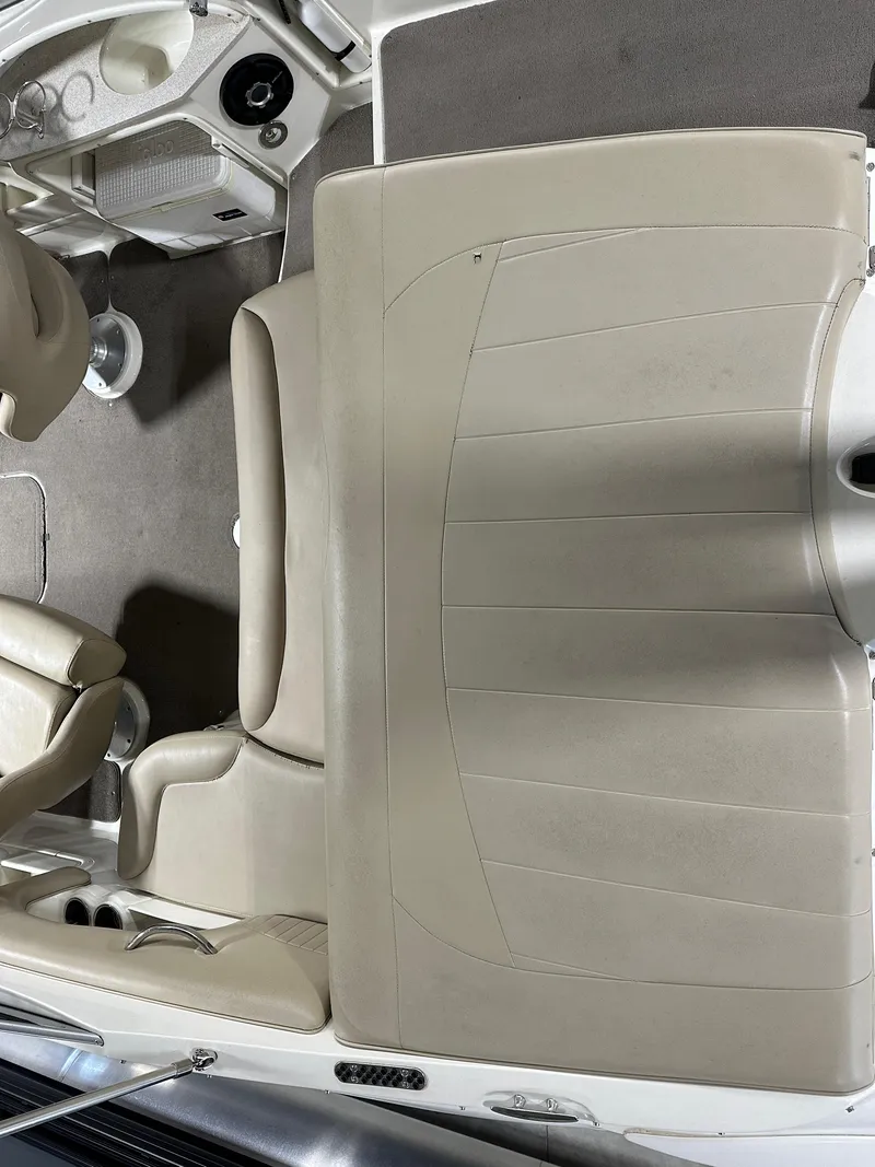 Slide: The Image of 2015 Stingray 215 LR boat interior with beige seating and carpeted flooring. - 12