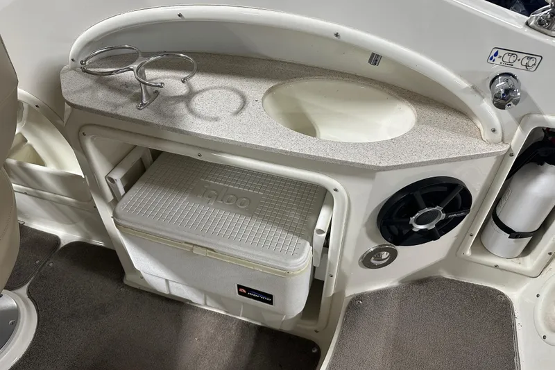 Slide: The Image of 2015 Stingray 215 LR boat interior with sink, cup holders, and storage compartment. - 14