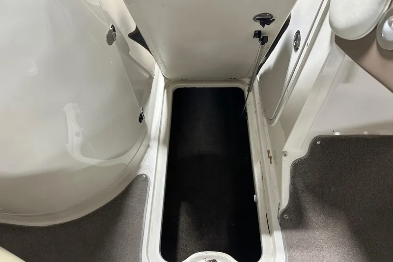 Slide: The Image of 2015 Stingray 215 LR boat interior storage compartment with carpeted flooring. - 15