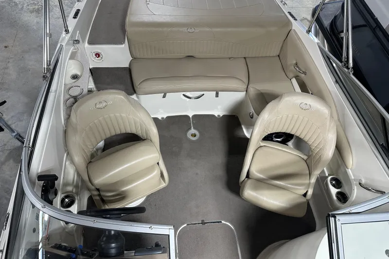Slide: The Image of 2015 Stingray 215 LR boat interior with beige seating and steering wheel. - 16