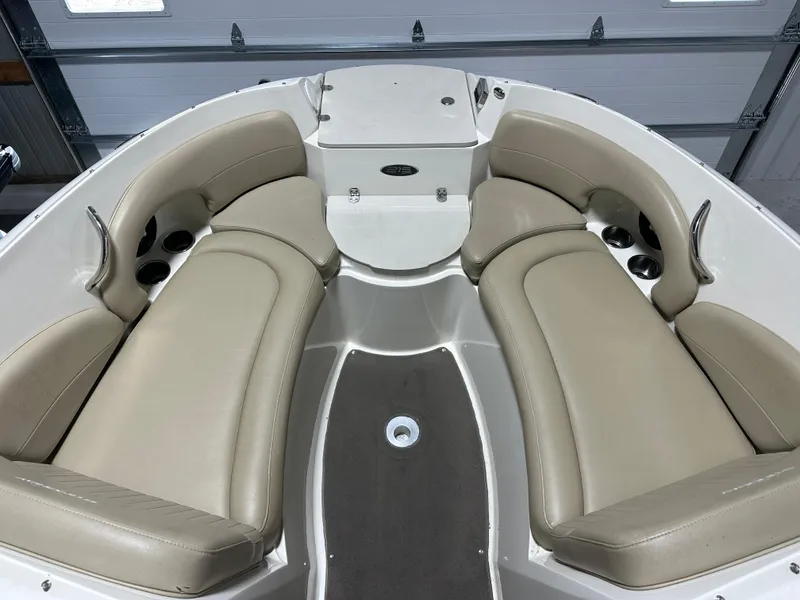 Slide: The Image of 2015 Stingray 215 LR boat interior with beige seating and cup holders. - 3