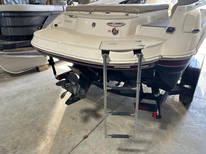 Slide: The Image of 2015 Stingray 215 LR boat with extended swim platform and ladder in a garage. - 4