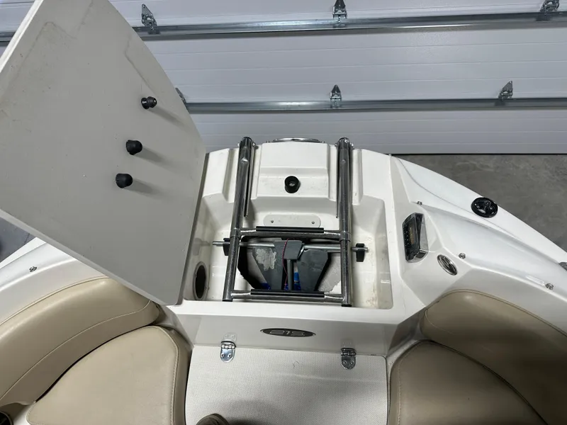 Slide: The Image of 2015 Stingray 215 LR boat with open storage compartment and ladder. - 9