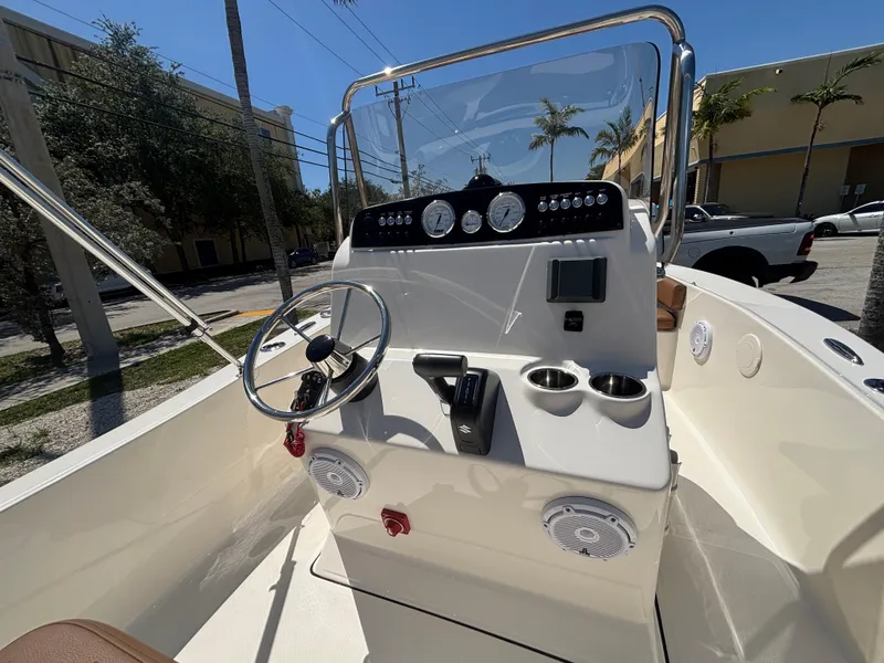 Slide: The Image of 2025 Pioneer 180 Islander boat console with steering wheel, gauges, and cup holders. - 10