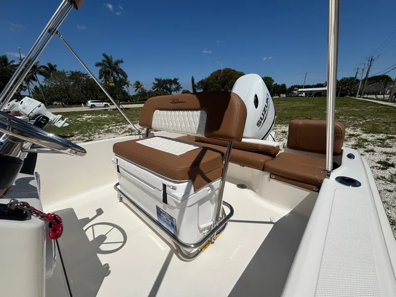Slide: The Image of 2025 Pioneer 180 Islander boat interior with brown seating and Suzuki outboard motor. - 12