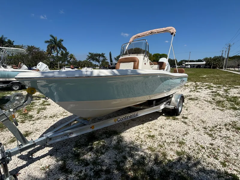 Slide: The Image of 2025 Pioneer 180 Islander boat on trailer, parked outdoors under clear blue sky. - 3