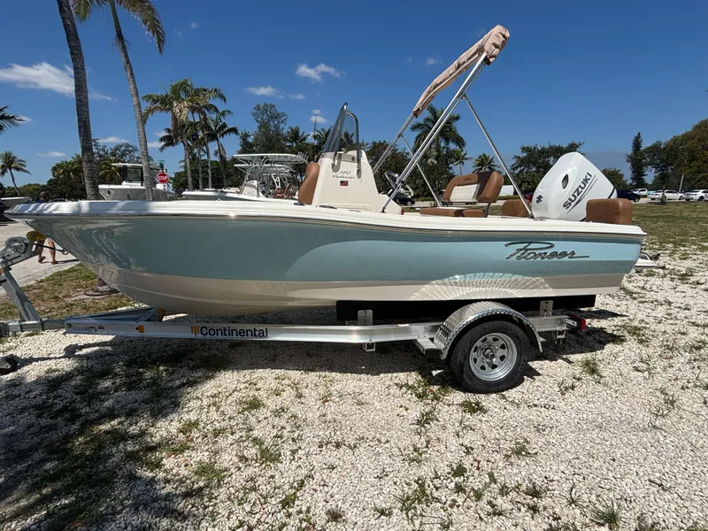 Slide: The Image of 2025 Pioneer 180 Islander boat on trailer, parked outdoors with palm trees in the background. - 4