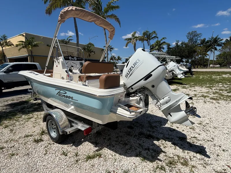Slide: The Image of 2025 Pioneer 180 Islander boat with Suzuki outboard motor, parked outdoors under clear sky. - 5
