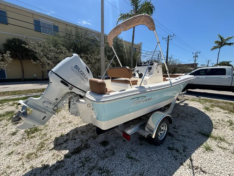 Slide: The Image of 2025 Pioneer 180 Islander boat with Suzuki outboard motor on a trailer, parked outdoors. - 7