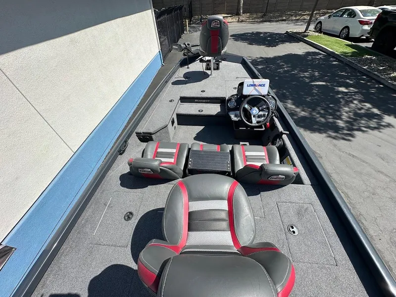 Slide: The Image of 2023 Ranger RT178 boat interior with seating and steering wheel, parked outdoors. - 18