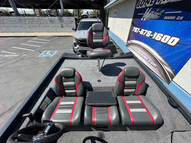 Slide: The Image of 2023 Ranger RT178 boat interior with gray and red seats in a parking lot. - 21