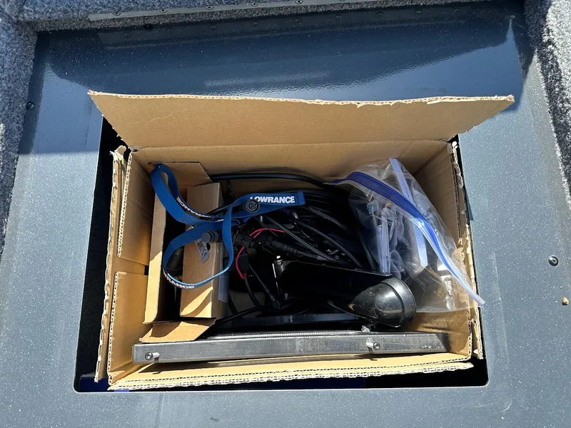 Slide: The Image of Cardboard box with electronic equipment inside a 2023 Ranger RT178 boat compartment. - 37