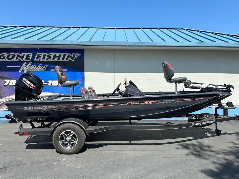 Slide: The Image of 2023 Ranger RT178 fishing boat on trailer, parked outdoors, with blue building background. - 6