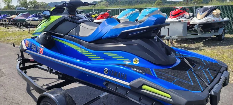 Slide: The Image of 2024 Yamaha Boats VX Limited HO jet ski in vibrant blue and green on a trailer. - 5