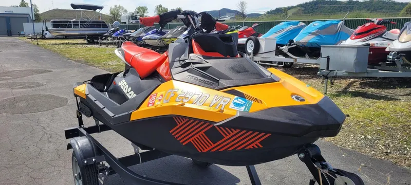 Slide: The Image of 2019 Sea-Doo Spark Trixx 3up iBR with sound system on trailer, vibrant orange and black design. - 3