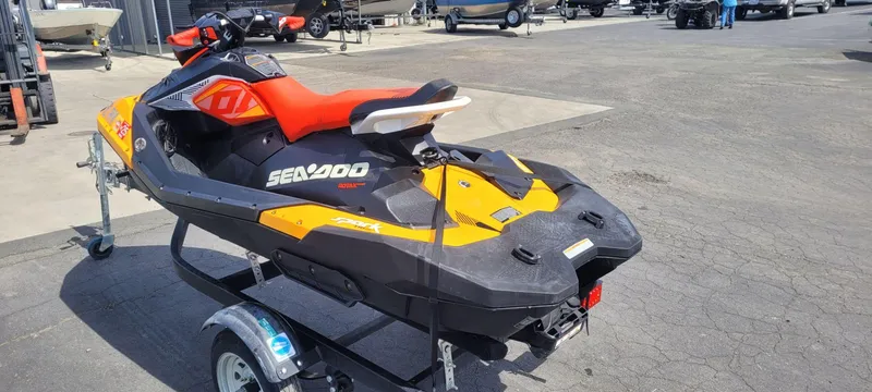 Slide: The Image of 2019 Sea-Doo Spark Trixx 3up iBR with sound system on trailer, vibrant orange and black design. - 4