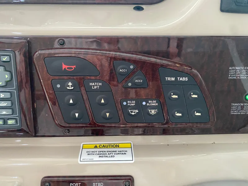 Slide: The Image of Control panel of a 2009 Sea Ray 350 Sundancer boat with various switches and caution label. - 29