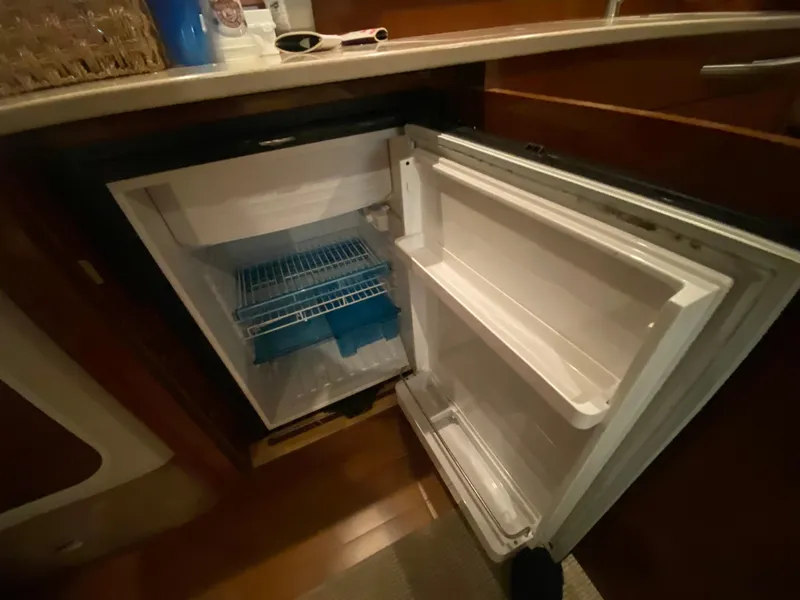 Slide: The Image of Open refrigerator inside 2009 Sea Ray 350 Sundancer yacht, showcasing interior storage space. - 35