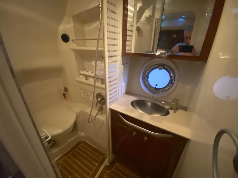 Slide: The Image of 2009 Sea Ray 350 Sundancer bathroom with shower, sink, and porthole window. - 41