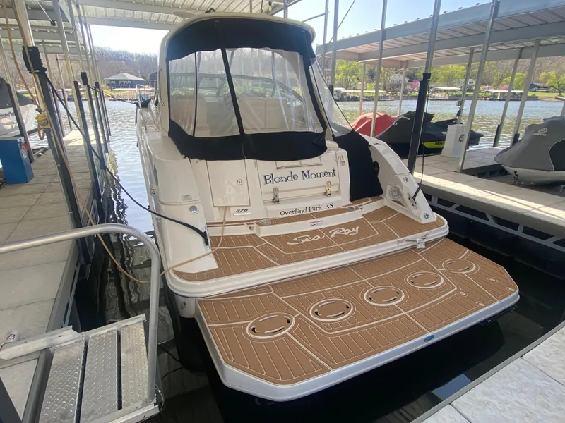 Slide: The Image of 2009 Sea Ray 350 Sundancer docked, featuring spacious deck and covered seating area. - 7
