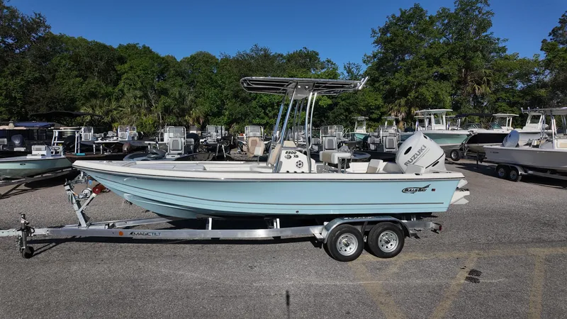 Slide: The Image of 2025 Bulls Bay 2200XS boat on trailer, parked outdoors with trees in background. - 10