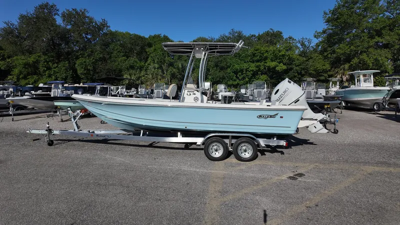 Slide: The Image of 2025 Bulls Bay 2200XS boat on trailer in outdoor lot, surrounded by trees. - 13