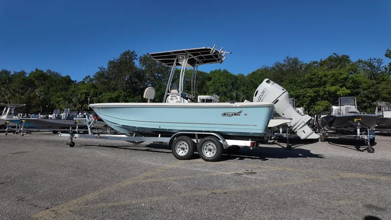 Slide: The Image of 2025 Bulls Bay 2200XS boat on trailer, parked outdoors under clear blue sky. - 15