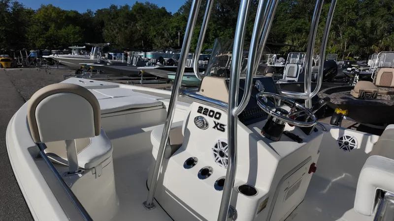 Slide: The Image of 2025 Bulls Bay 2200XS boat with sleek design and modern console, docked outdoors. - 24